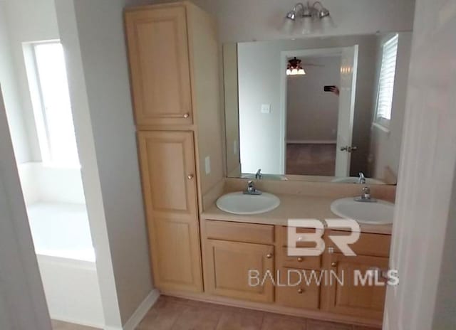 bathroom with double sink vanity, tile patterned flooring, and a healthy amount of sunlight