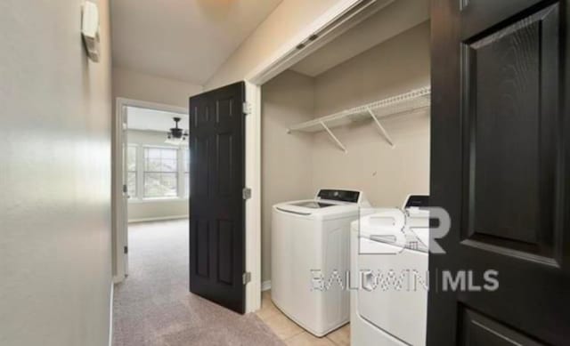 laundry room with light colored carpet and separate washer and dryer