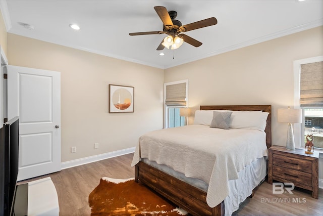 bedroom featuring ceiling fan, ornamental molding, wood finished floors, and baseboards