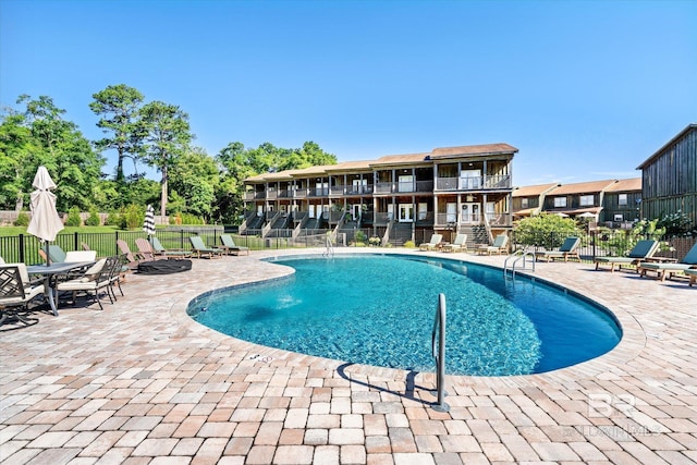 pool with fence and a patio