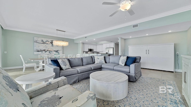 living room featuring light tile patterned floors, ceiling fan with notable chandelier, and ornamental molding