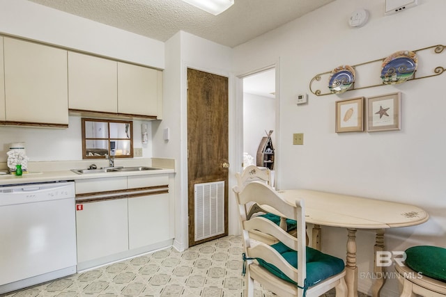 kitchen with sink, a textured ceiling, and dishwasher