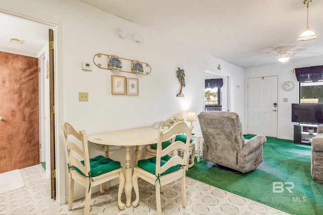 dining space featuring carpet floors and ceiling fan