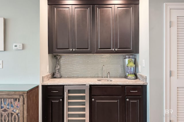 bar with wine cooler, indoor wet bar, a sink, and decorative backsplash