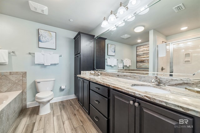 full bathroom featuring double vanity, a stall shower, visible vents, toilet, and a sink