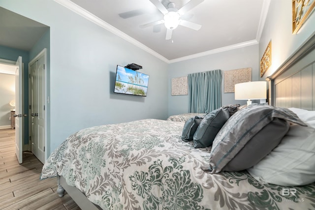 bedroom with ornamental molding, wood finished floors, a ceiling fan, and baseboards