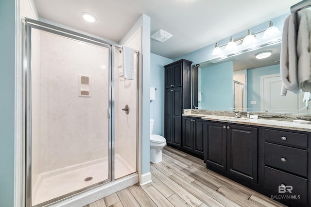 full bath featuring toilet, vanity, visible vents, wood tiled floor, and a stall shower