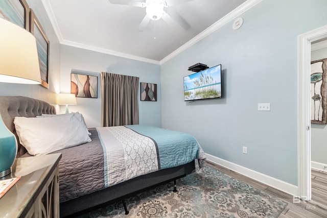 bedroom with baseboards, crown molding, and wood finished floors