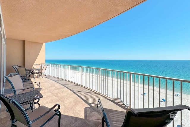 balcony with a water view and a beach view