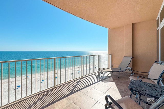 balcony featuring a water view and a beach view