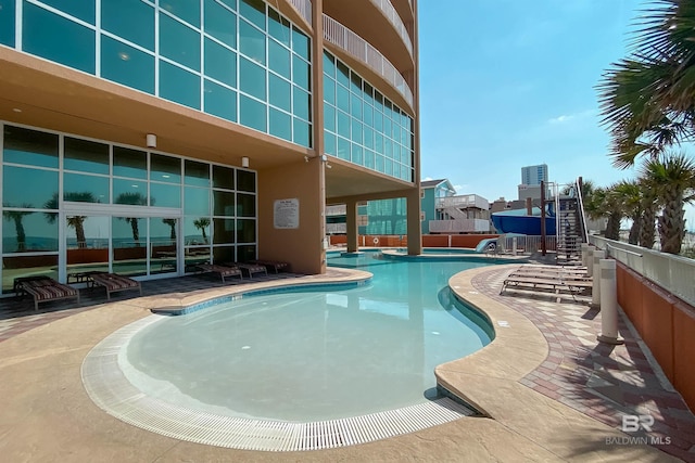 community pool featuring stairs and a patio