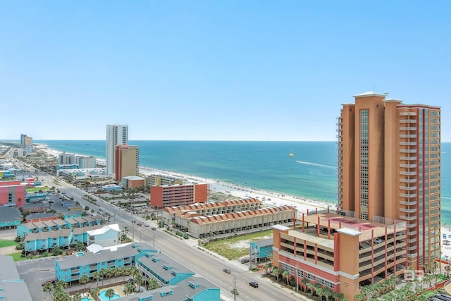 drone / aerial view featuring a water view, a view of the beach, and a city view