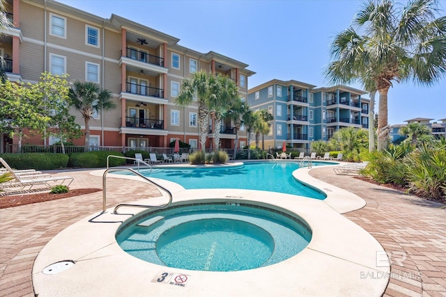 view of pool with a hot tub and a patio area