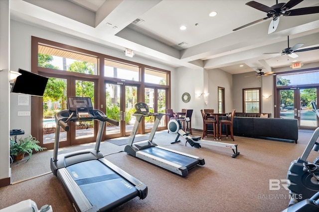 exercise room featuring a towering ceiling, carpet flooring, and french doors