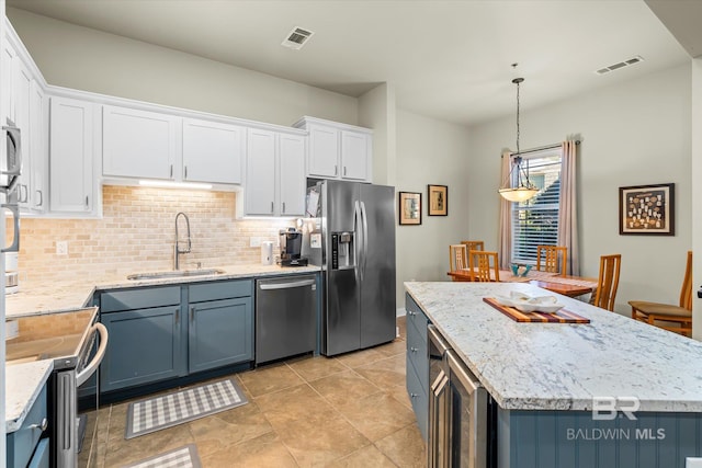 kitchen featuring pendant lighting, sink, appliances with stainless steel finishes, white cabinets, and blue cabinets