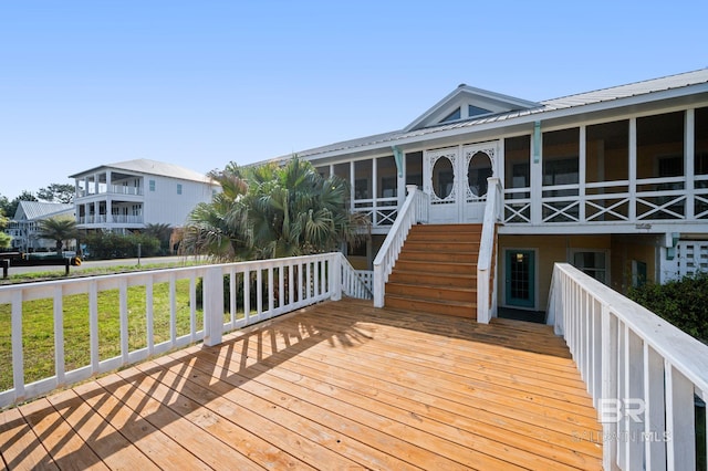 wooden deck featuring a sunroom and stairs