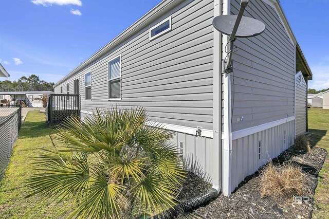 view of property exterior with fence and a lawn