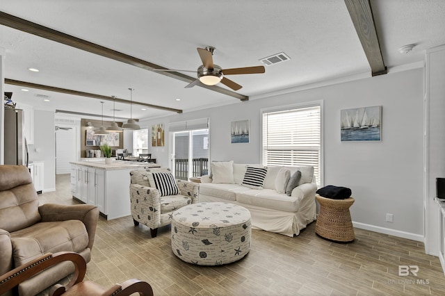 living area featuring baseboards, visible vents, ornamental molding, beamed ceiling, and wood finish floors