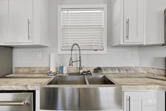 kitchen featuring light countertops, a sink, and white cabinetry