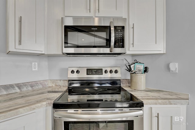 kitchen with white cabinetry, appliances with stainless steel finishes, and light countertops