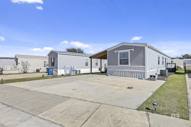 exterior space featuring a carport, cooling unit, and driveway