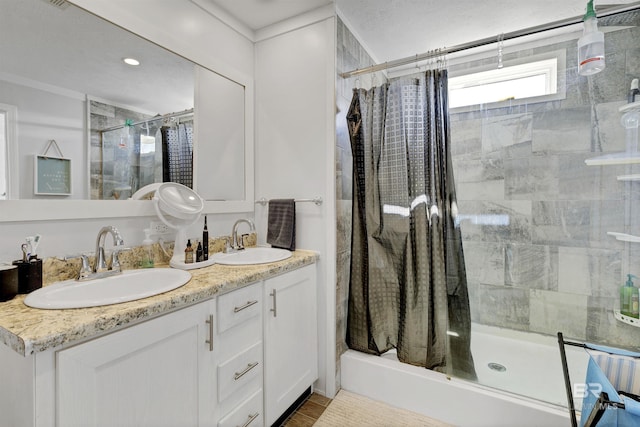 bathroom with double vanity, a sink, and a shower with shower door