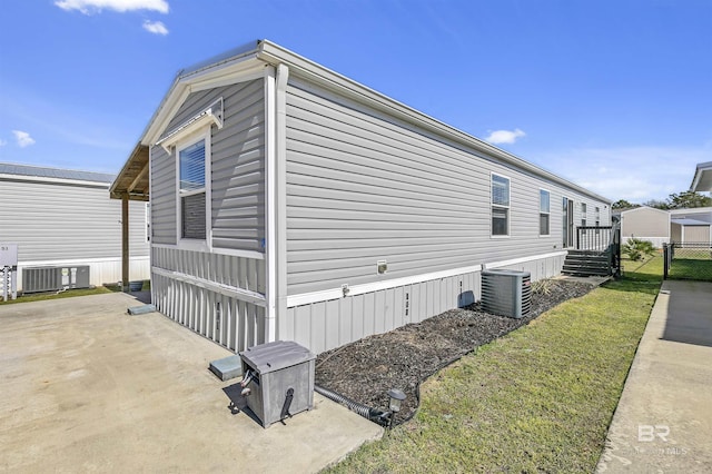 view of side of home with a patio, central AC unit, and fence