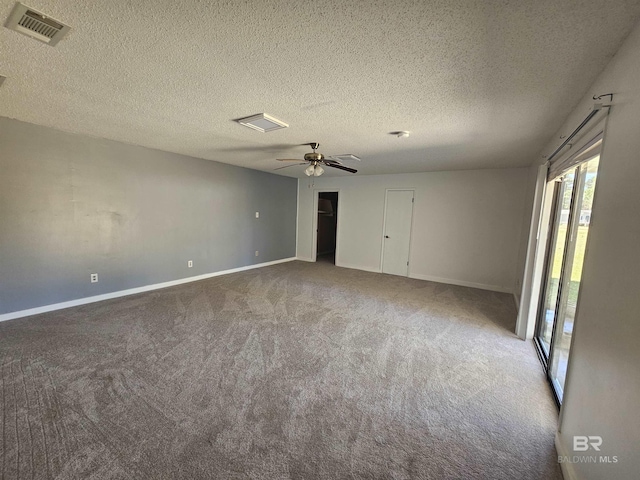 empty room with a ceiling fan, a textured ceiling, baseboards, visible vents, and carpet
