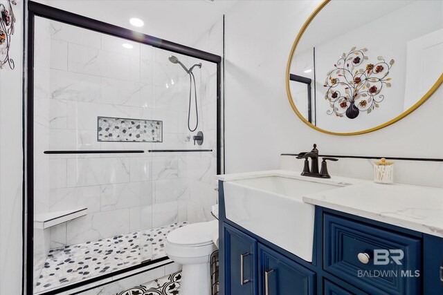 bathroom with vanity, toilet, and a shower with door