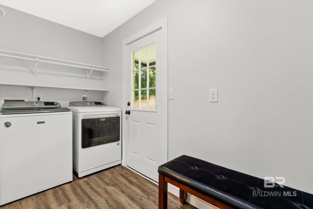 laundry area featuring washing machine and clothes dryer and hardwood / wood-style flooring