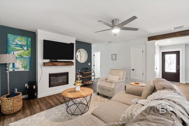 living room featuring a fireplace, dark hardwood / wood-style flooring, and ceiling fan