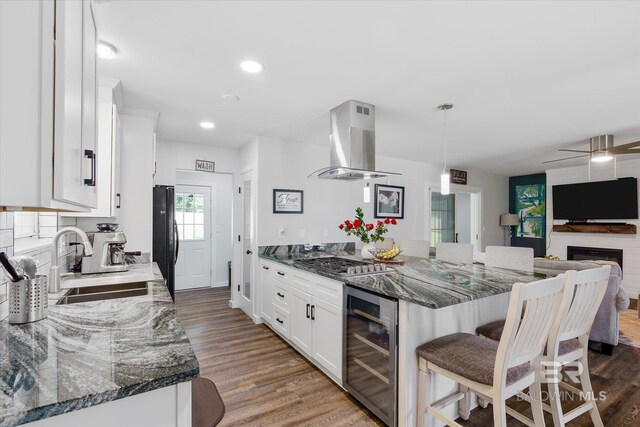 kitchen featuring dark stone counters, beverage cooler, white cabinets, and extractor fan