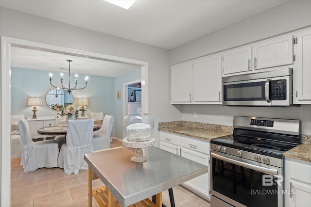 1116 Linlen Ave, Mobile, AL 36609 - kitchen featuring stainless steel appliances, white cabinetry, and light stone counters