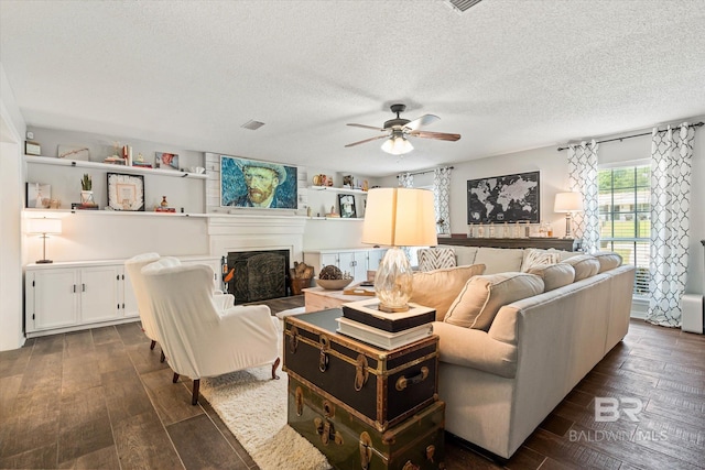 1116 Linlen Ave, Mobile, AL 36609 - living area featuring a ceiling fan, a fireplace, a textured ceiling, and dark wood-type flooring