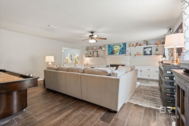 1116 Linlen Ave, Mobile, AL 36609 - living room featuring a fireplace, dark wood-style floors, a ceiling fan, a textured ceiling, and billiards