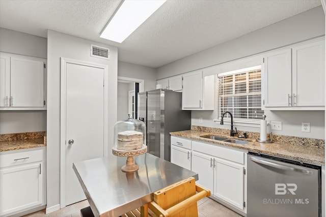 1116 Linlen Ave, Mobile, AL 36609 - kitchen with a sink, stainless steel appliances, a textured ceiling, white cabinetry, and light stone counters