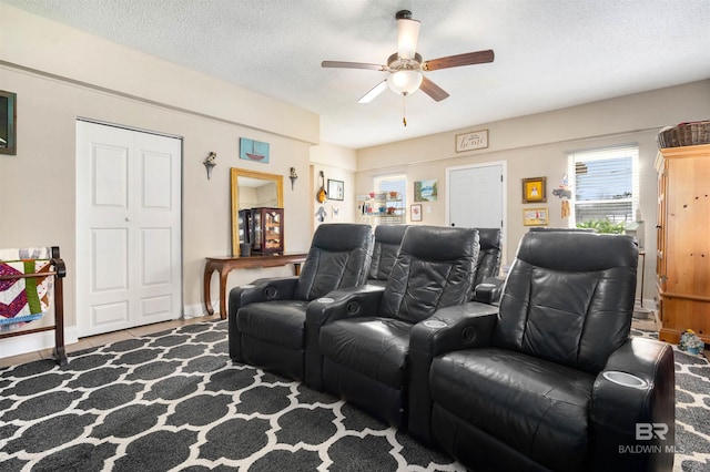 cinema room with a textured ceiling and a ceiling fan