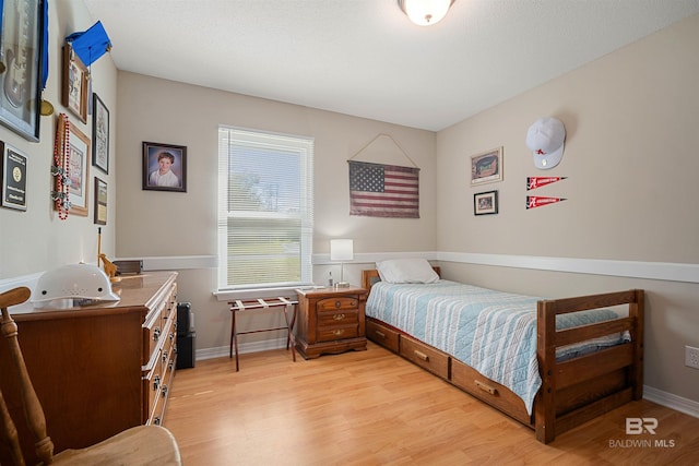 bedroom featuring baseboards and light wood finished floors