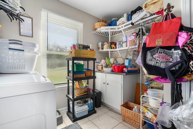 laundry room featuring a wealth of natural light, cabinet space, and light tile patterned floors