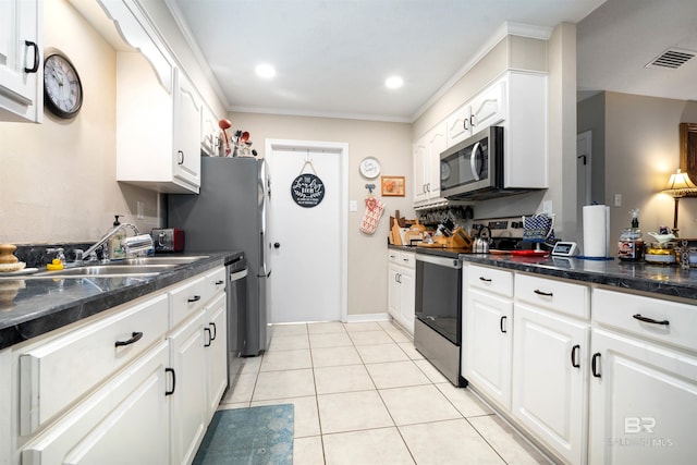 kitchen featuring light tile patterned floors, visible vents, a sink, stainless steel appliances, and dark countertops