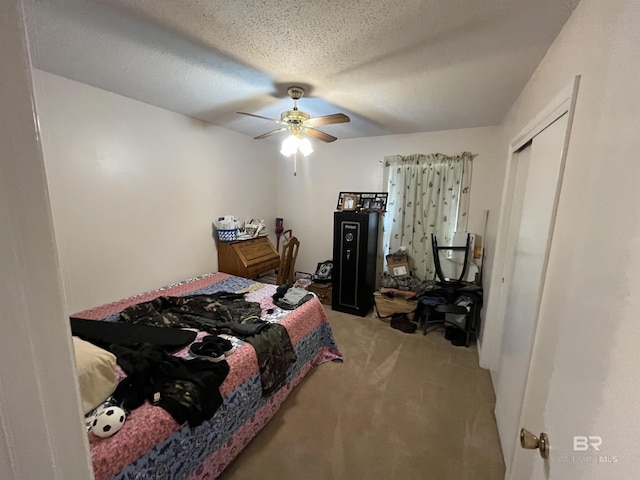 carpeted bedroom with ceiling fan, a closet, and a textured ceiling