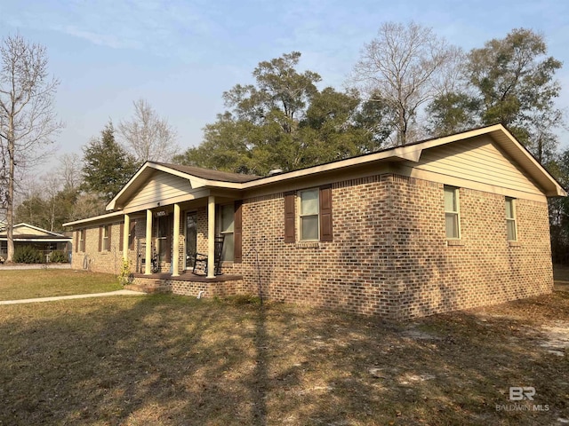 ranch-style house featuring a front lawn and covered porch