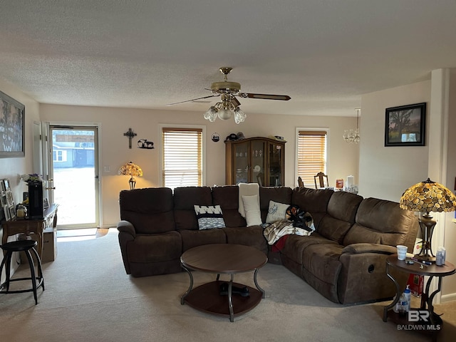 living room with carpet flooring, ceiling fan, and a textured ceiling