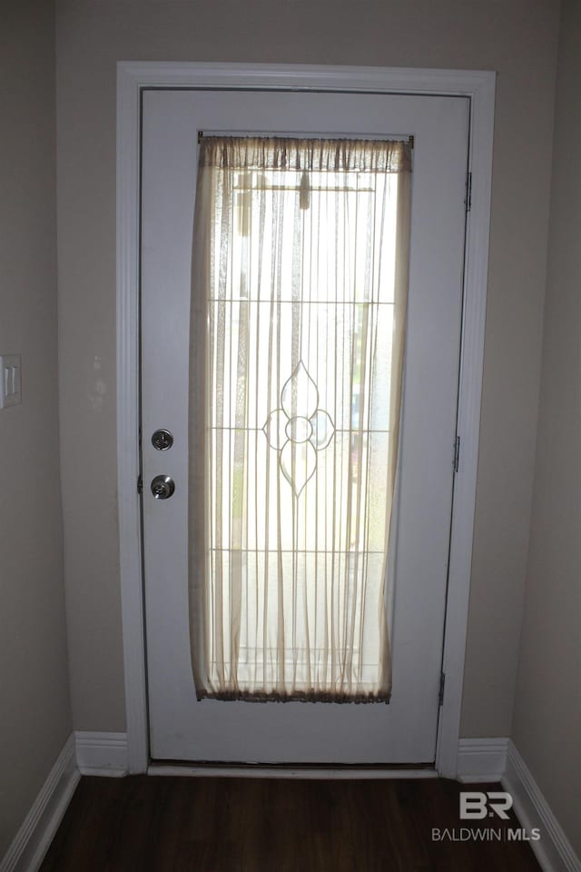 entryway with dark wood-style flooring and baseboards