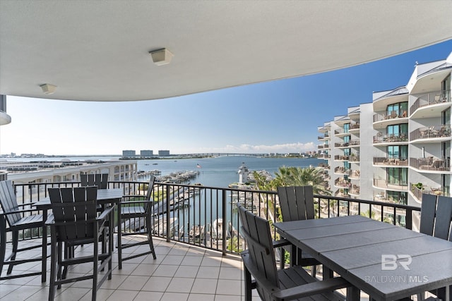 balcony featuring outdoor dining space and a water view