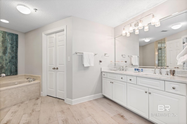 bathroom with double vanity, a shower stall, a textured ceiling, wood finished floors, and a bath