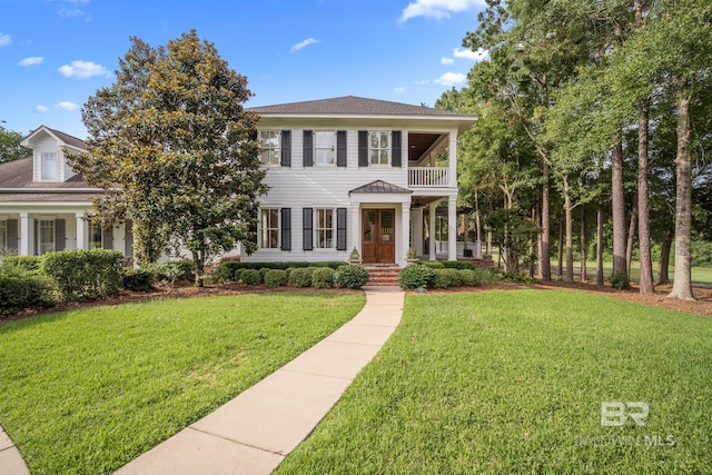 view of front of home featuring a front lawn and a balcony