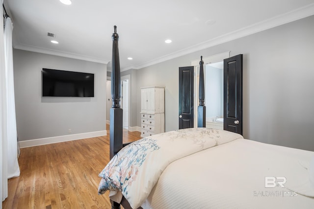 bedroom featuring ornamental molding, ensuite bath, and light hardwood / wood-style flooring