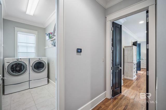 washroom featuring ornamental molding, light tile flooring, and washing machine and clothes dryer