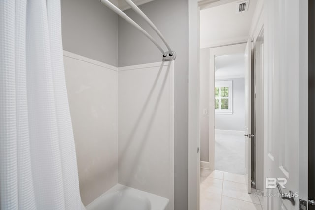 bathroom featuring tile flooring and shower / bath combo